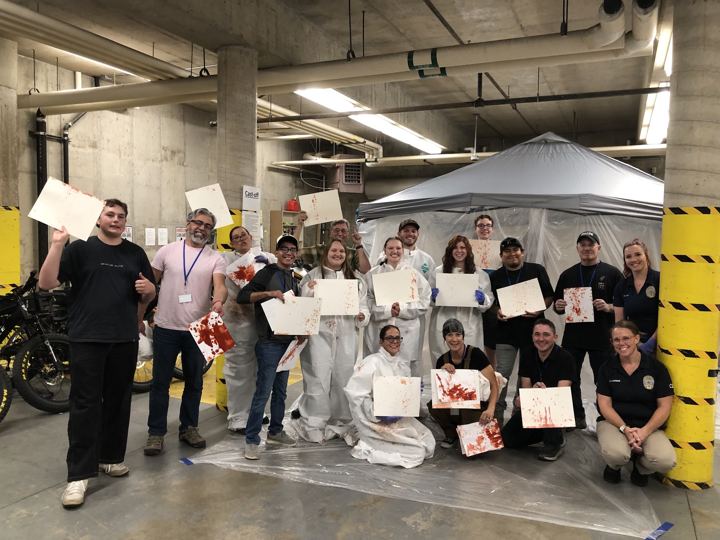 Class group photo holding their blood-spatter pattern papers