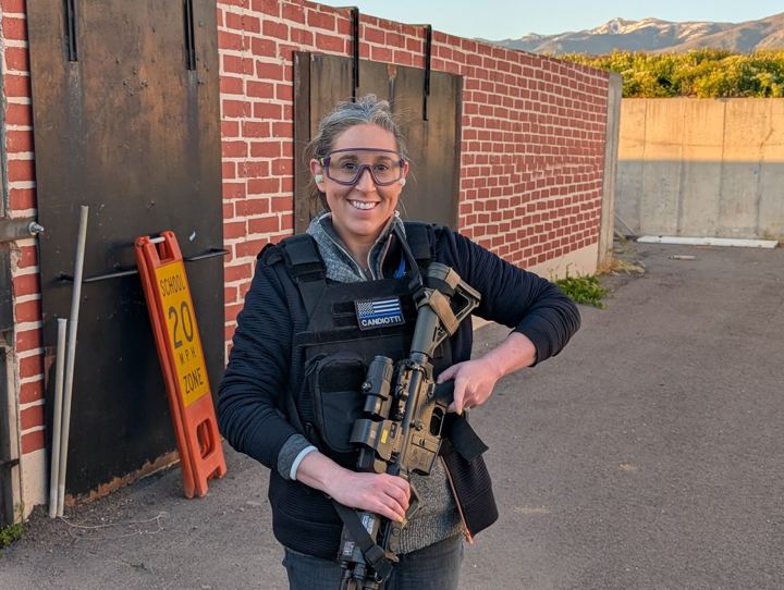 Smiling student wearing a tactical vest at the range